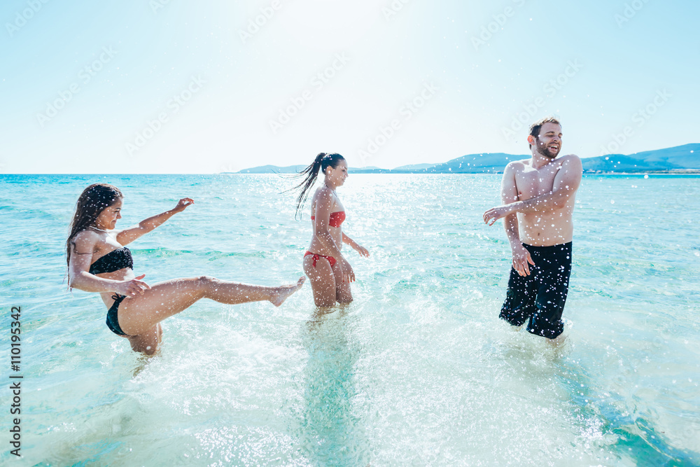 group of young multiethnic friends women and men at the beach in summertime having fun in the water splashing - happiness, friendship, having fun concept group of young multiethnic friends women and men at the beach in summertime having fun in the water splashing - happiness, friendship, having fun concept