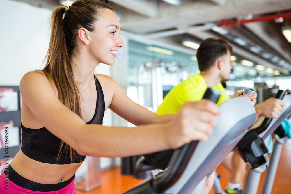 Group of people exercising their legs doing cardio training in g Group of people exercising their legs doing cardio training in g
