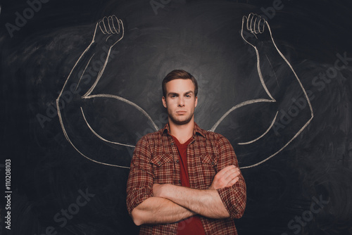 Young handsome man in shirt with drawn powerful hands