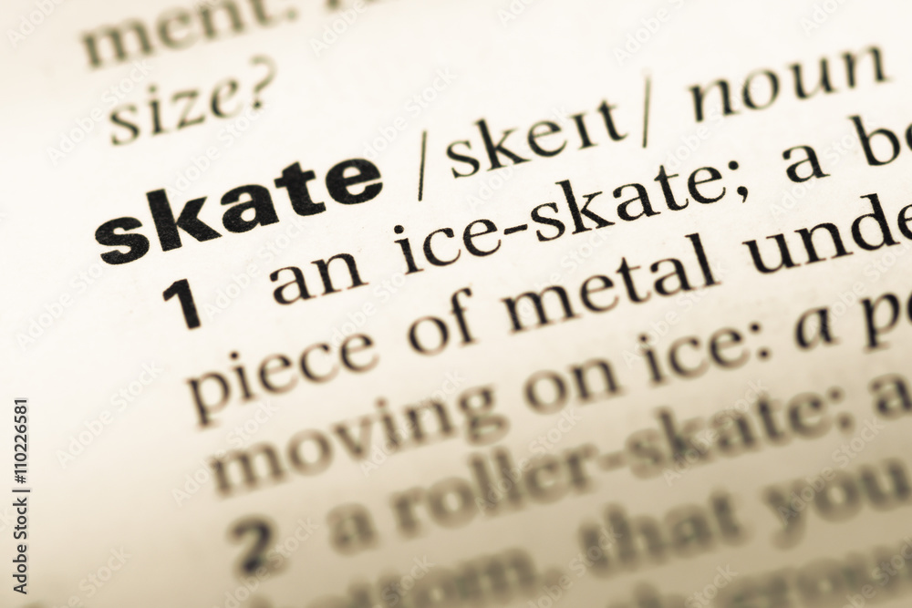 Close up of old English dictionary page with word skate Close up of old English dictionary page with word skate