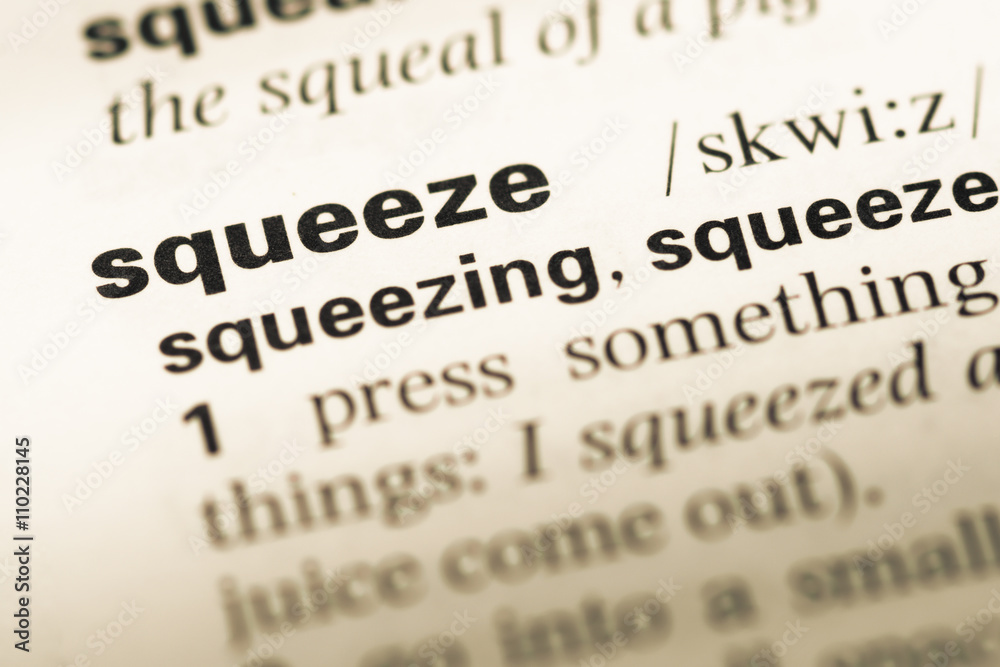 Close up of old English dictionary page with word squeeze Close up of old English dictionary page with word squeeze