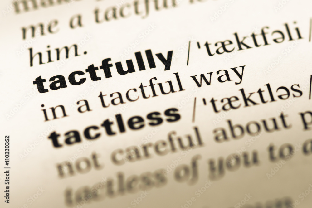 Close up of old English dictionary page with word tactfully Close up of old English dictionary page with word tactfully