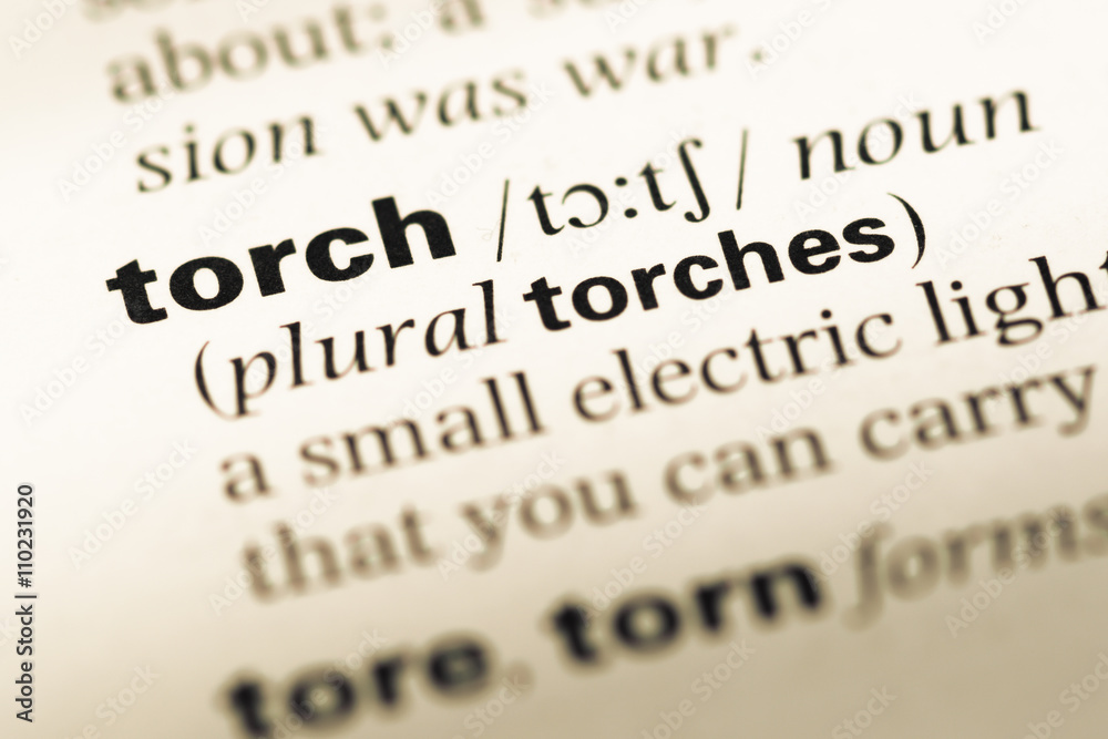 Close up of old English dictionary page with word torch Close up of old English dictionary page with word torch