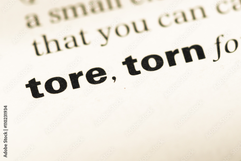 Close up of old English dictionary page with word tore torn Close up of old English dictionary page with word tore torn