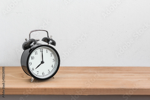 Vintage alarm clock on wood shelf  ( alarm clock show 8 o`clock