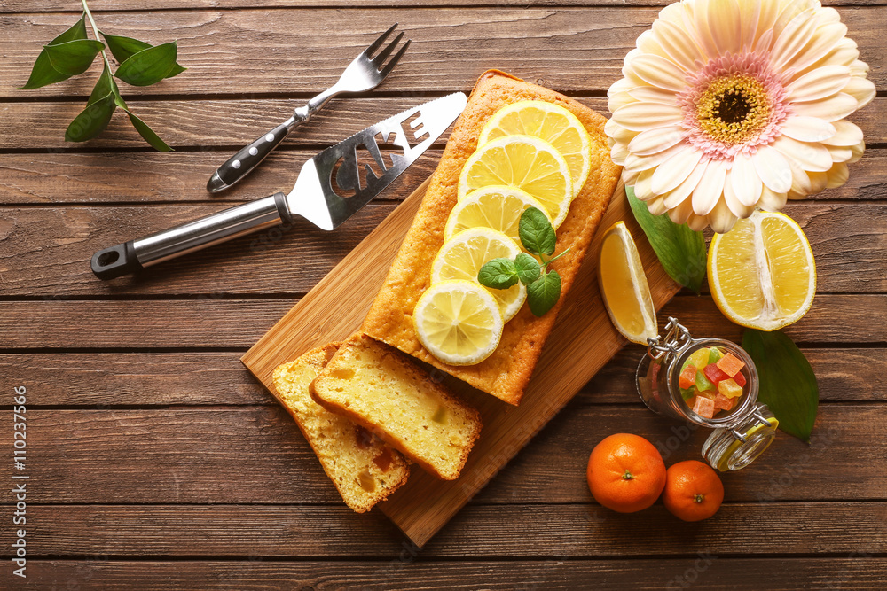 Delicious citrus cake loaf with lemons on wooden board