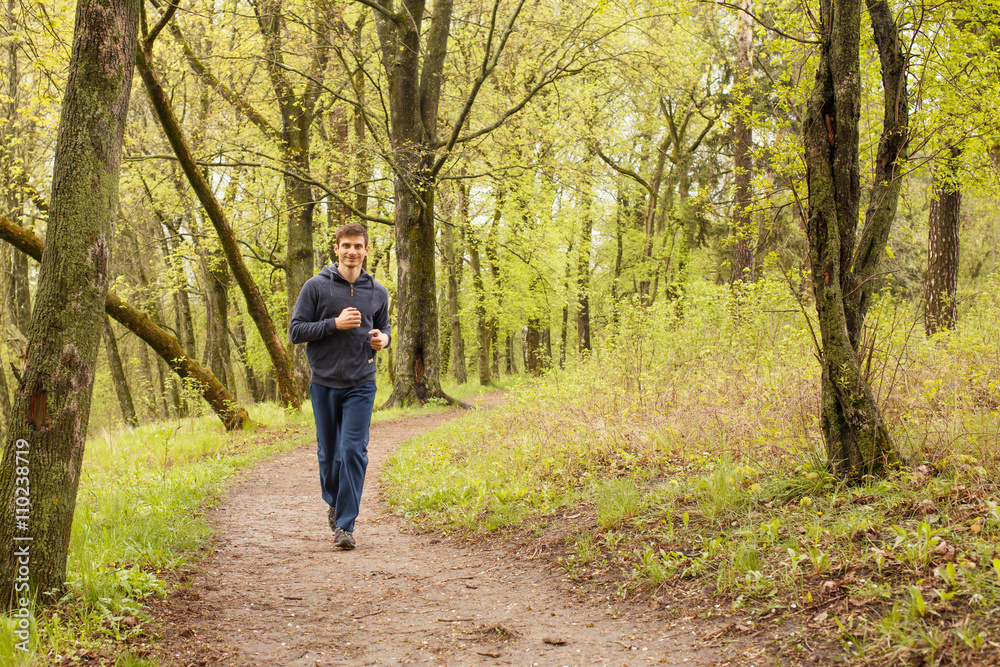 Young sporty man jogging in the morning forest Young sporty man jogging in the morning forest