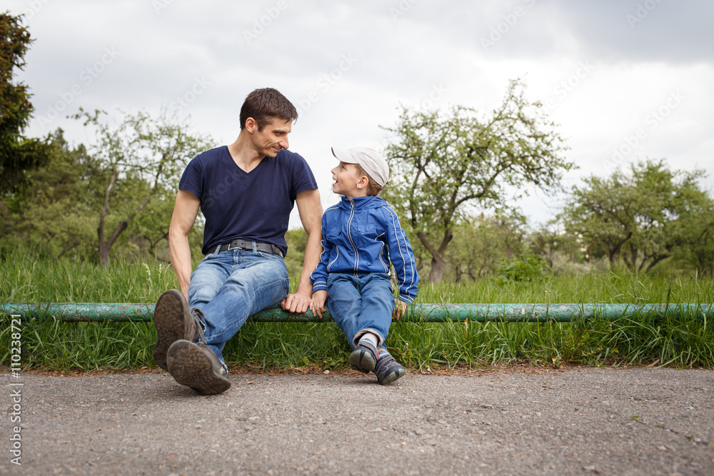Happy father and son sitting in the park