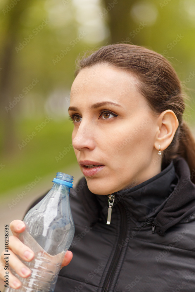 Young woman drinking water after workout jogging Young woman drinking water after workout jogging