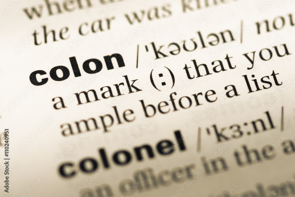 Close up of old English dictionary page with word colon Close up of old English dictionary page with word colon