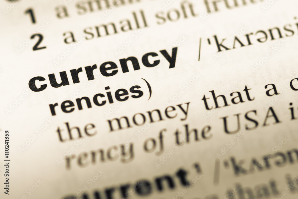 Close up of old English dictionary page with word currency