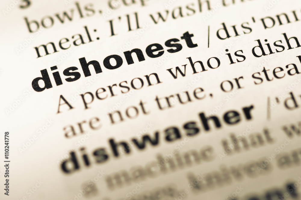 Close up of old English dictionary page with word dishonest Close up of old English dictionary page with word dishonest