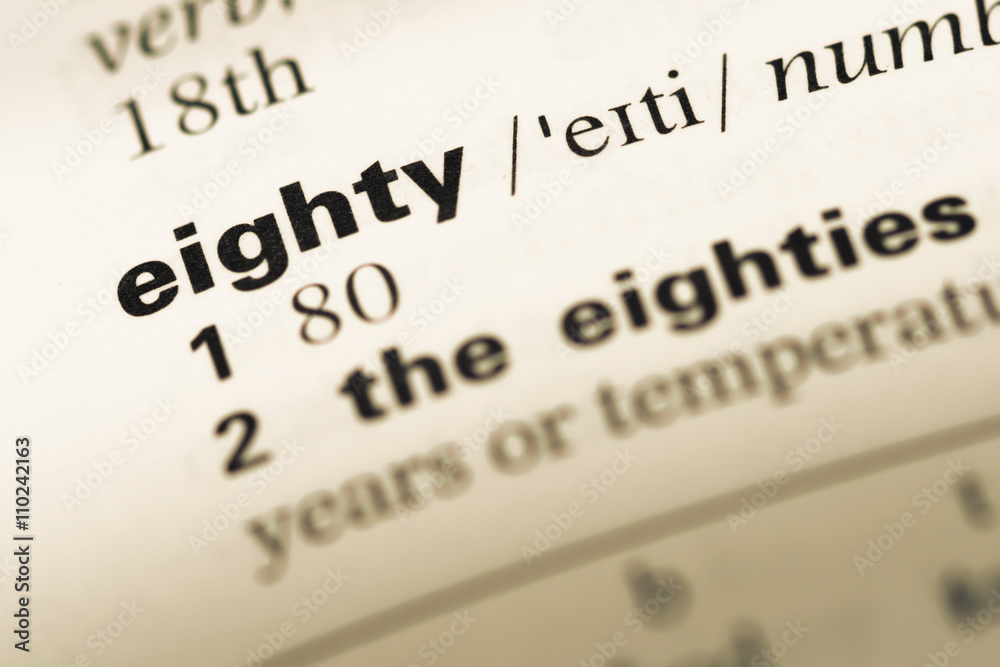 Close up of old English dictionary page with word eighty Close up of old English dictionary page with word eighty