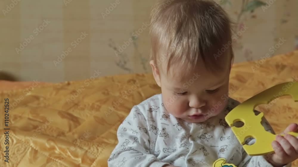Baby boy takes in her mouth bright toy Baby boy takes in her mouth bright toy