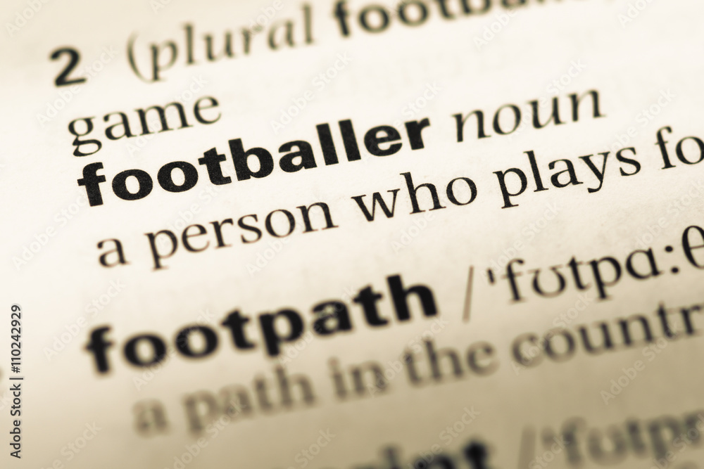 Close up of old English dictionary page with word footballer Close up of old English dictionary page with word footballer