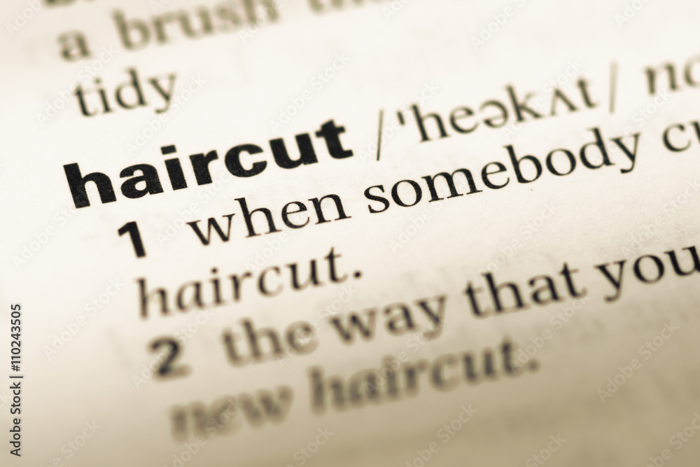 Close up of old English dictionary page with word haircut Close up of old English dictionary page with word haircut