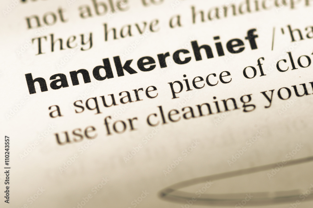 Obraz premium Close up of old English dictionary page with word handkerchief