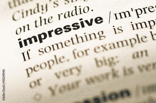 Close up of old English dictionary page with word impressive