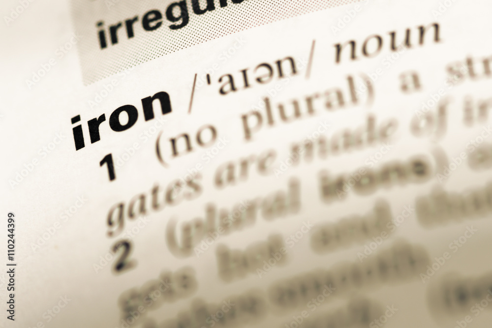 Close up of old English dictionary page with word iron Close up of old English dictionary page with word iron