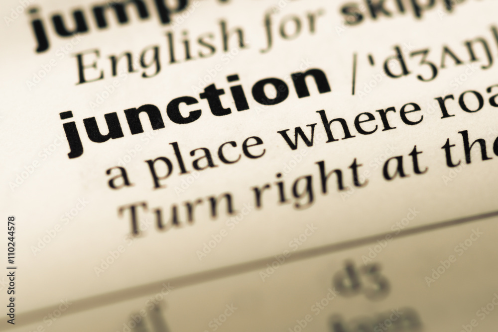 Close up of old English dictionary page with word junction Close up of old English dictionary page with word junction