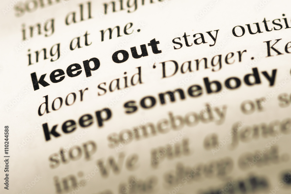 Close up of old English dictionary page with word keep out Close up of old English dictionary page with word keep out