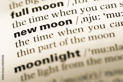 Close up of old English dictionary page with word new moon