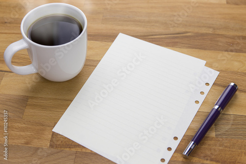 Workspace with hot coffee cup  note paper on wooden table