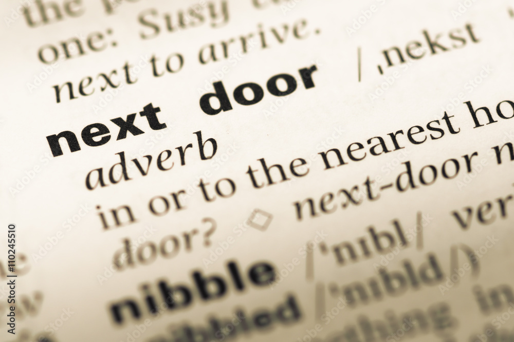 Close up of old English dictionary page with word next door Close up of old English dictionary page with word next door