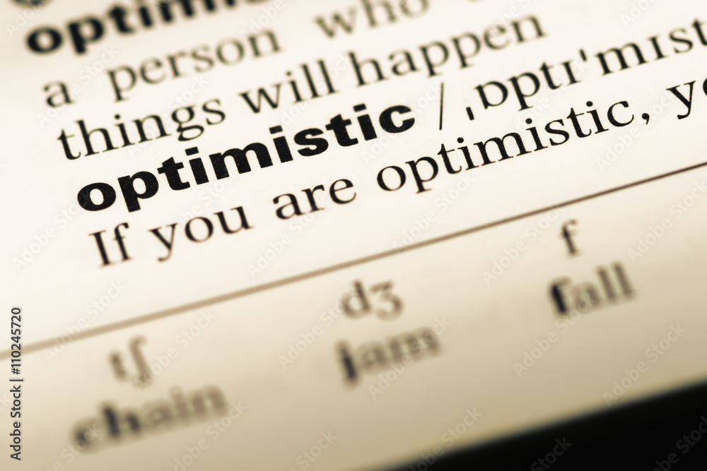 Close up of old English dictionary page with word optimistic Close up of old English dictionary page with word optimistic
