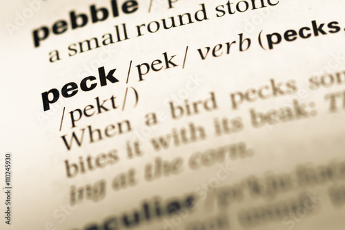 Close up of old English dictionary page with word peck photo