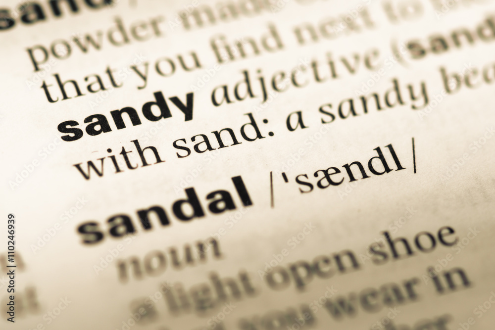 Fototapeta premium Close up of old English dictionary page with word sandy