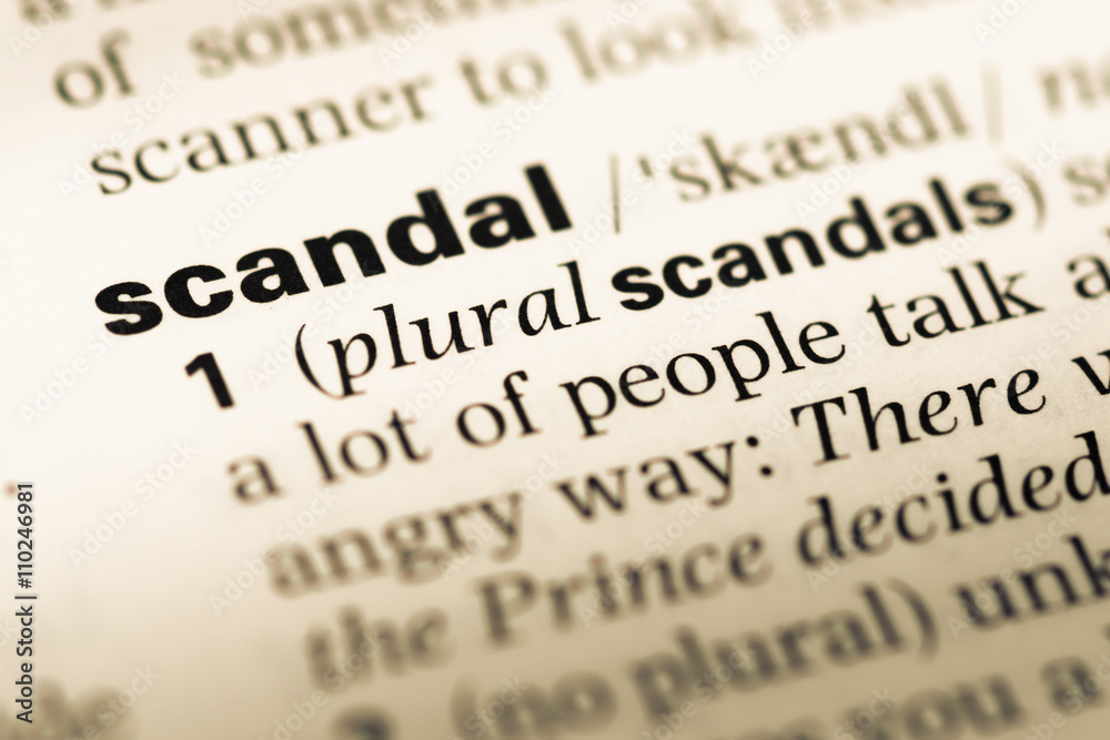 Obraz premium Close up of old English dictionary page with word scandal