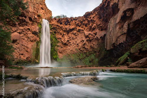 The impressive flow of Mooney Falls at the bottom of the Havasupai Canyon in the desert of Arizona.