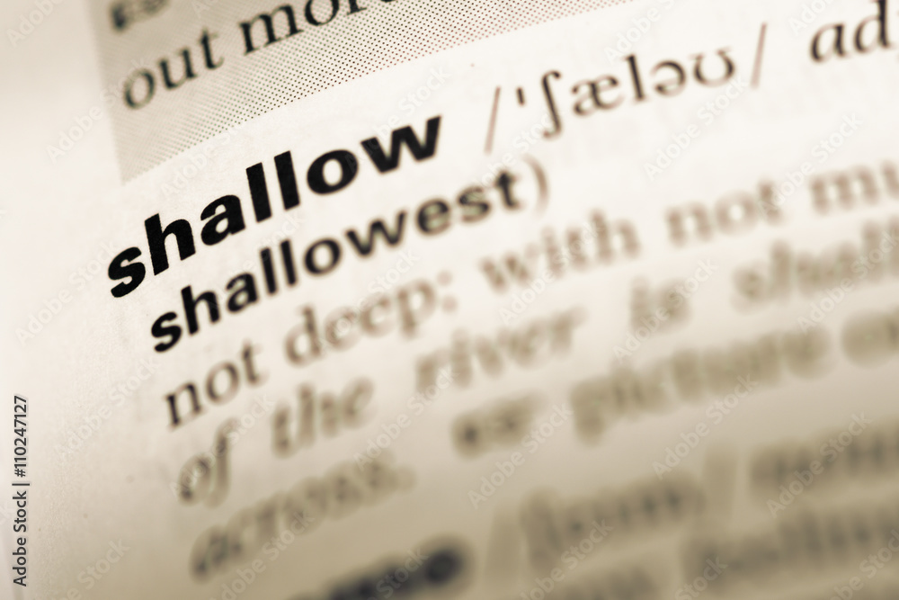 Close up of old English dictionary page with word shallow Close up of old English dictionary page with word shallow