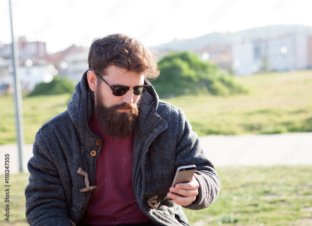 Young man with hipster look with the mobile Young man with hipster look with the mobile