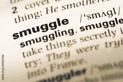 Close up of old English dictionary page with word smuggle