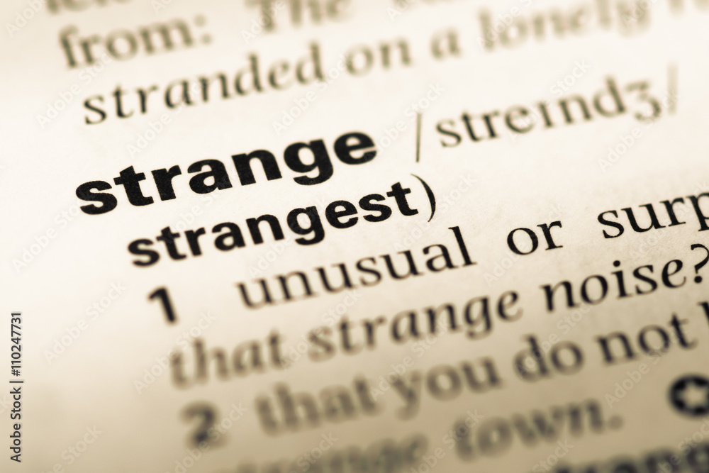 Close up of old English dictionary page with word strange Close up of old English dictionary page with word strange