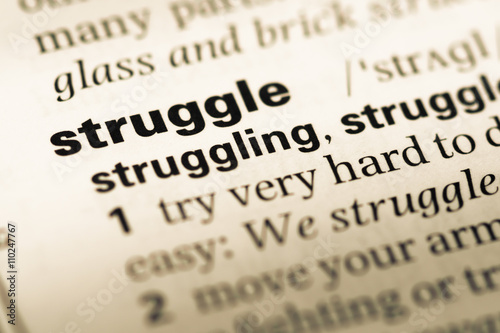 Canvas Print Close up of old English dictionary page with word struggle