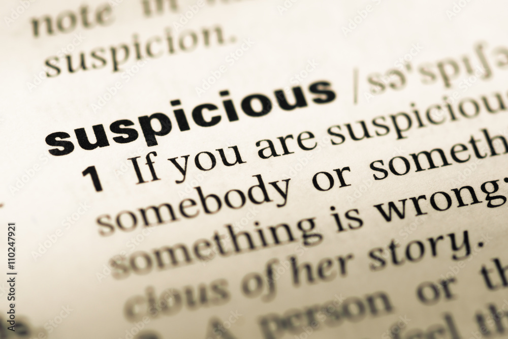 Close up of old English dictionary page with word suspicious
