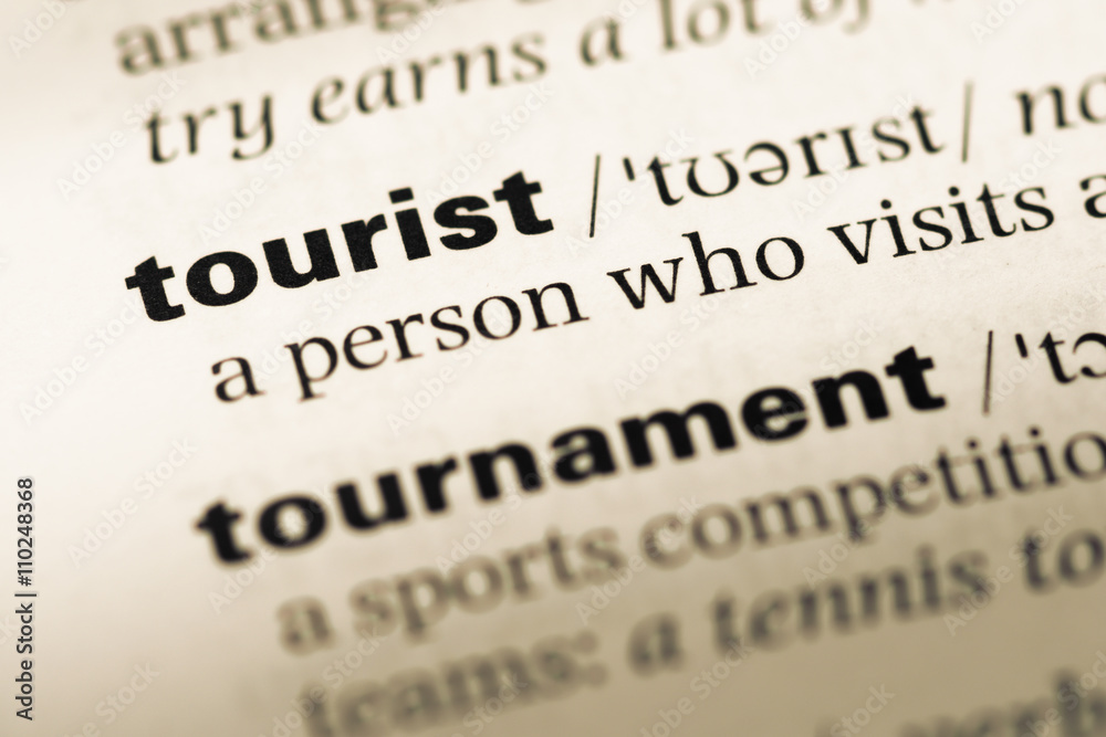 Close up of old English dictionary page with word tourist Close up of old English dictionary page with word tourist