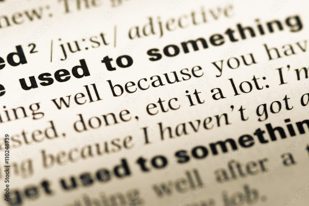Close up of old English dictionary page with word used to Close up of old English dictionary page with word used to