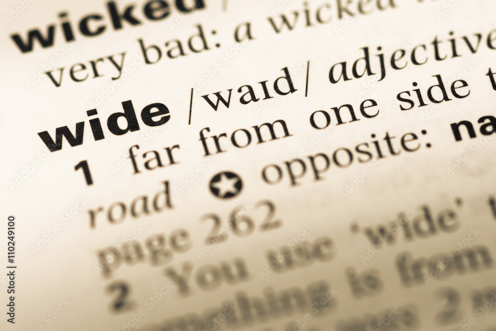 Close up of old English dictionary page with word wide Close up of old English dictionary page with word wide