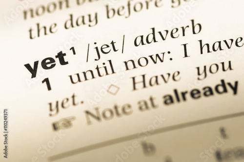 Close up of old English dictionary page with word yet photo