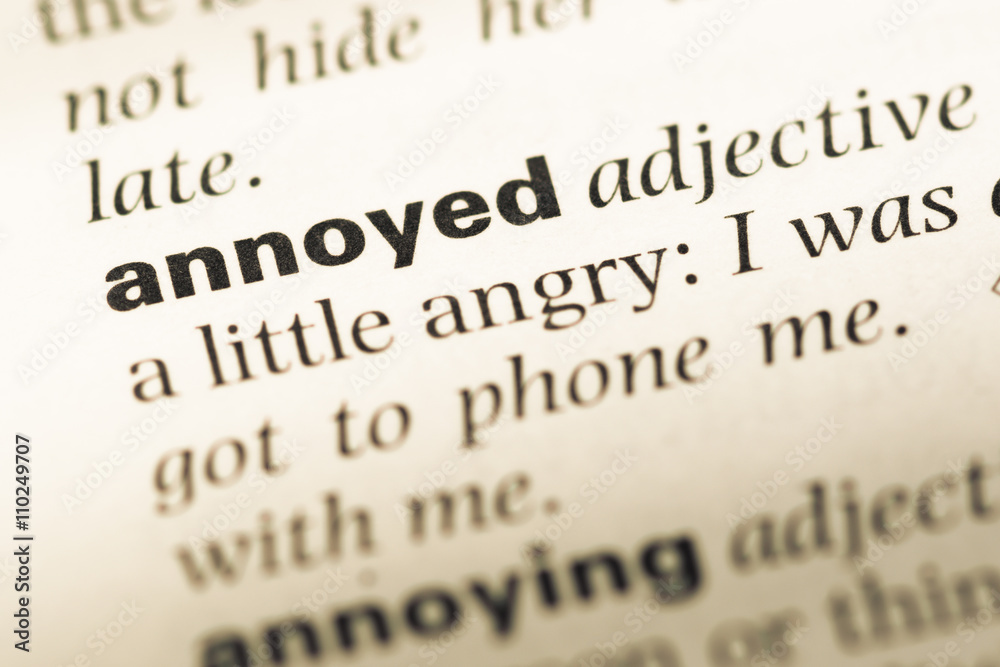 Obraz premium Close up of old English dictionary page with word annoyed