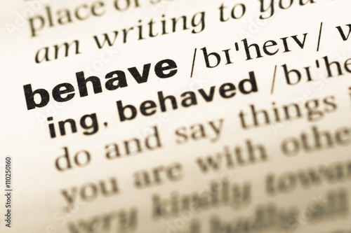 Close up of old English dictionary page with word behave