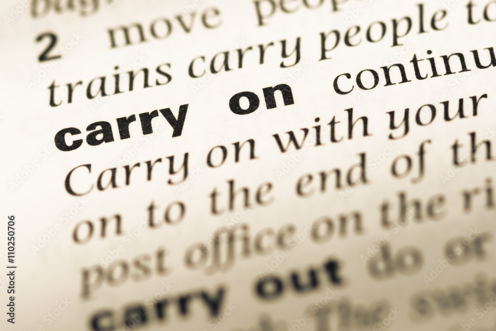 Close up of old English dictionary page with word carry on Close up of old English dictionary page with word carry on