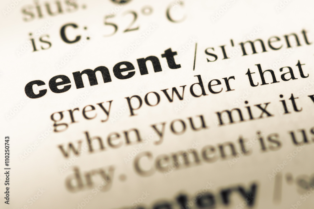 Close up of old English dictionary page with word cement Close up of old English dictionary page with word cement