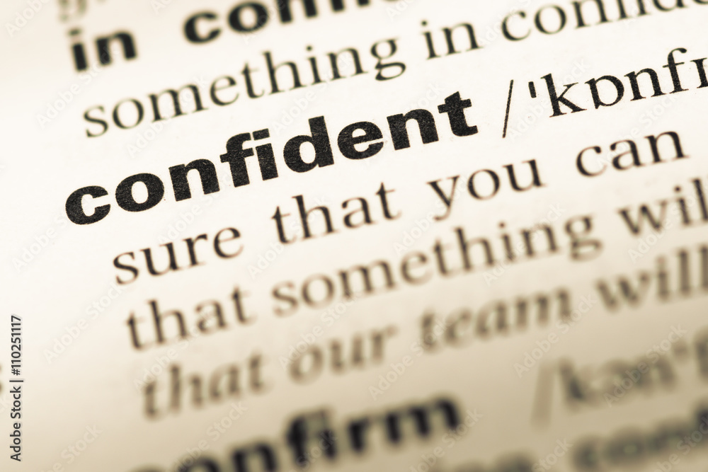 Close up of old English dictionary page with word confident Close up of old English dictionary page with word confident