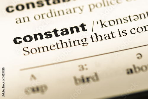 Close up of old English dictionary page with word constant
