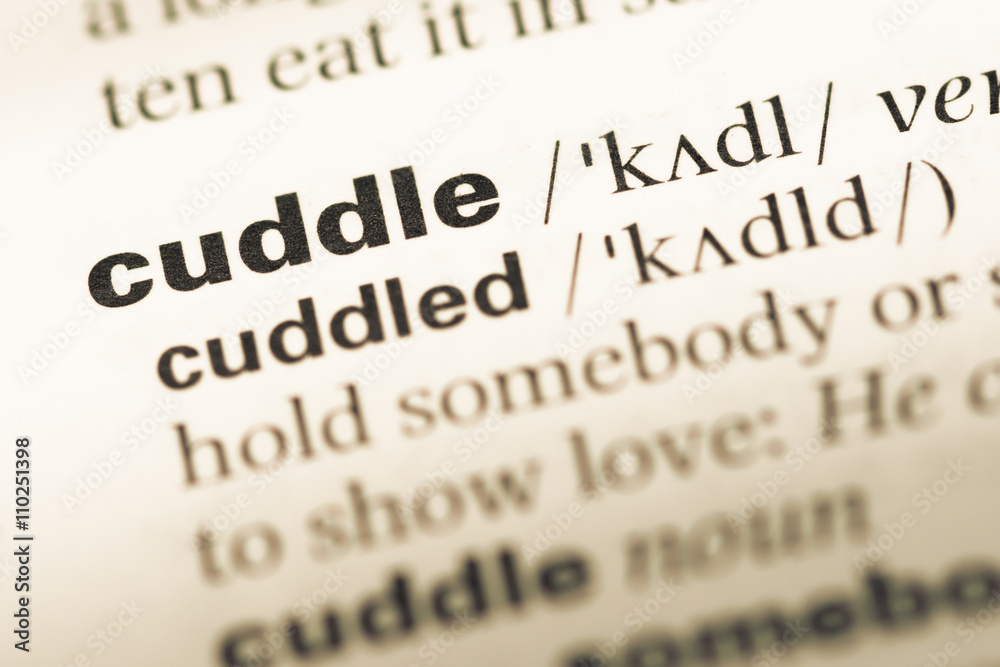 Obraz premium Close up of old English dictionary page with word cuddle